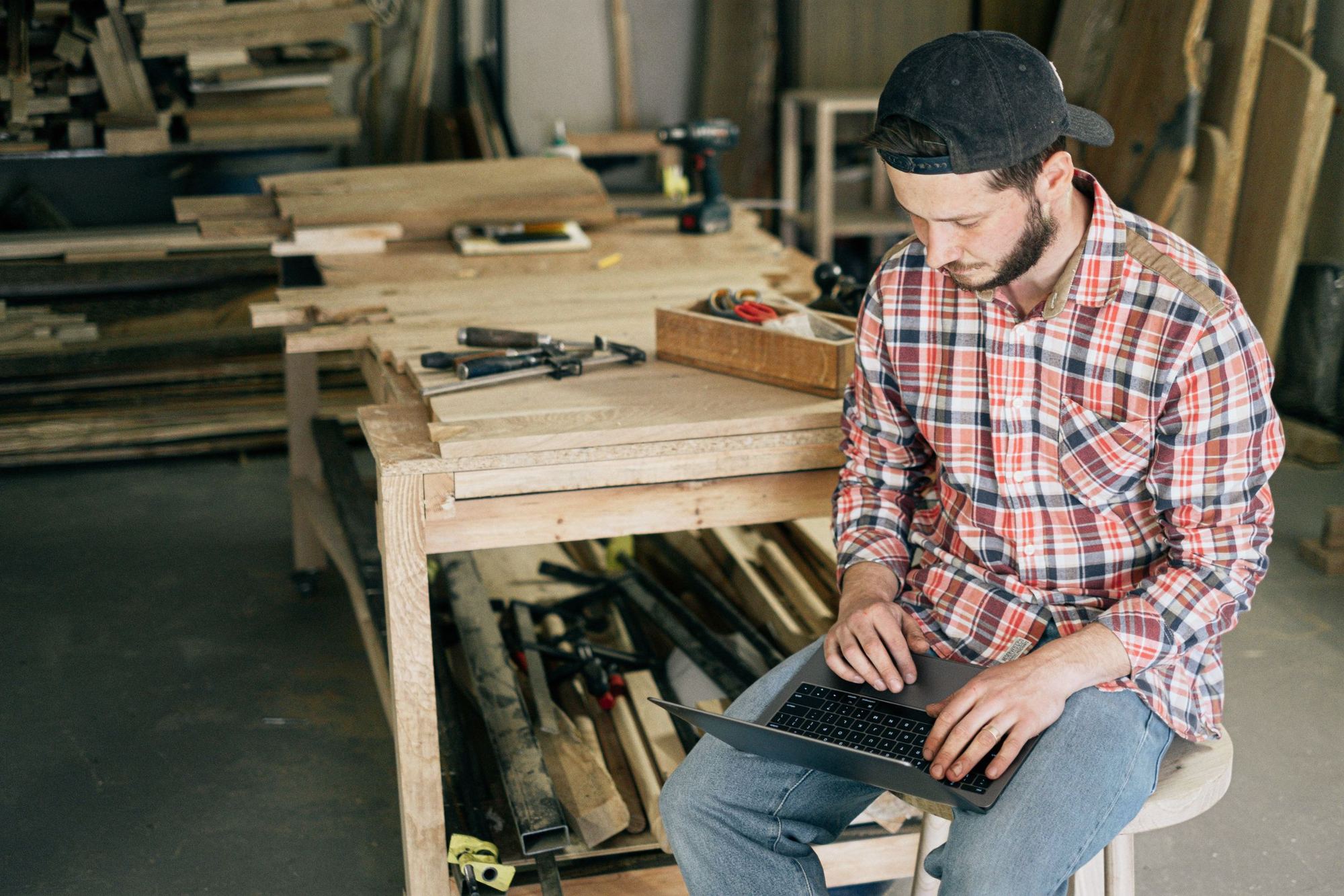 A business owner working on a laptop in his workshop. Illustrative photograph.